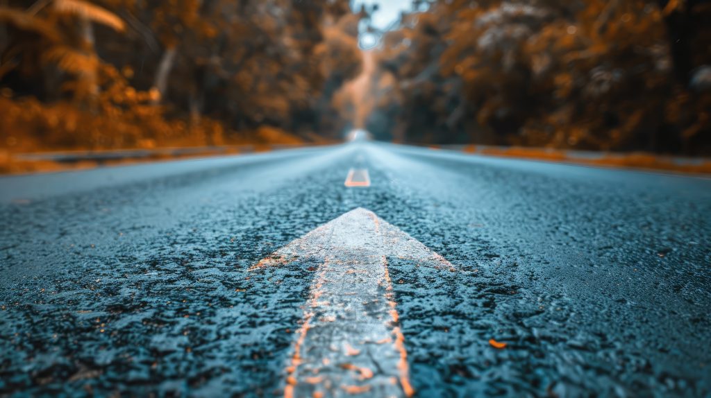 Dividing line down road painted as an arrow in Autumn scene.