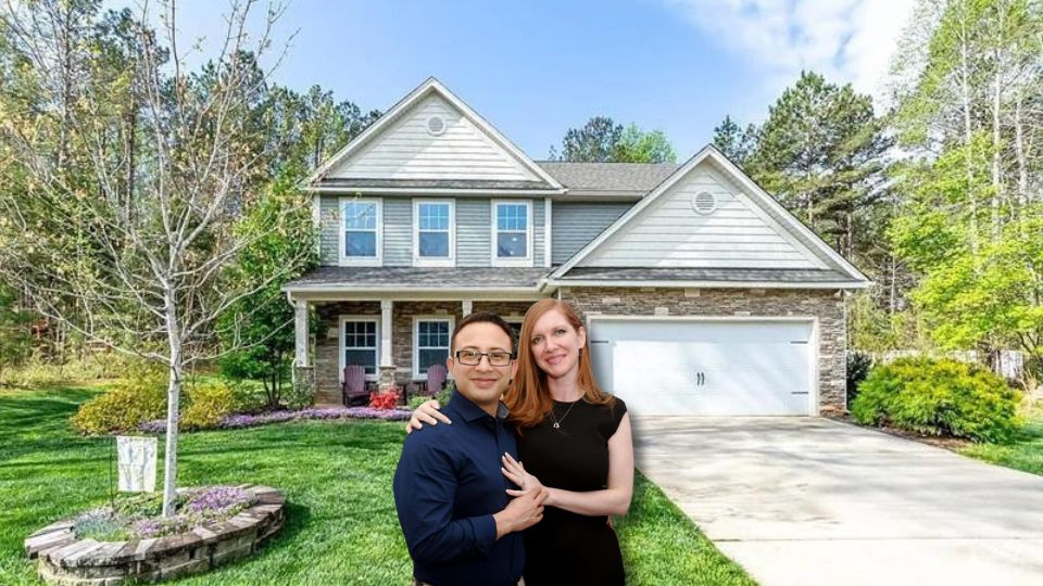 Man and women in front of house.